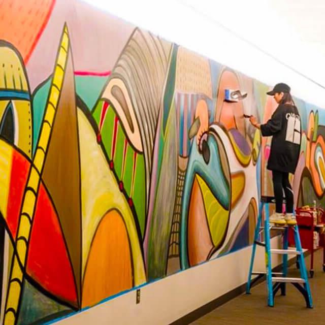 Lingshan Zheng paints a mural at the University of Hartford
